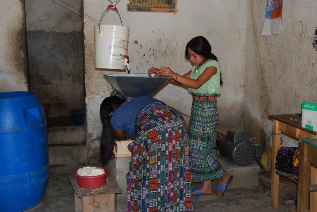 Jeunes filles moulant de la farine